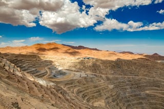 Open-pit copper mine with deep terraces in desert landscape